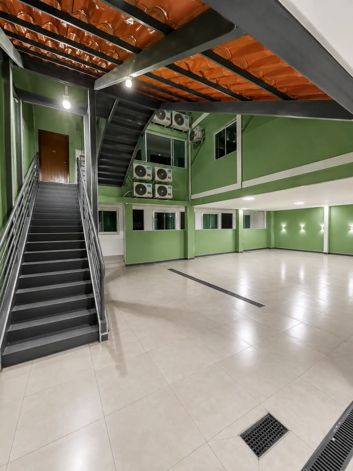 Térreo aberto do hotel com a escada que leva aos quartos